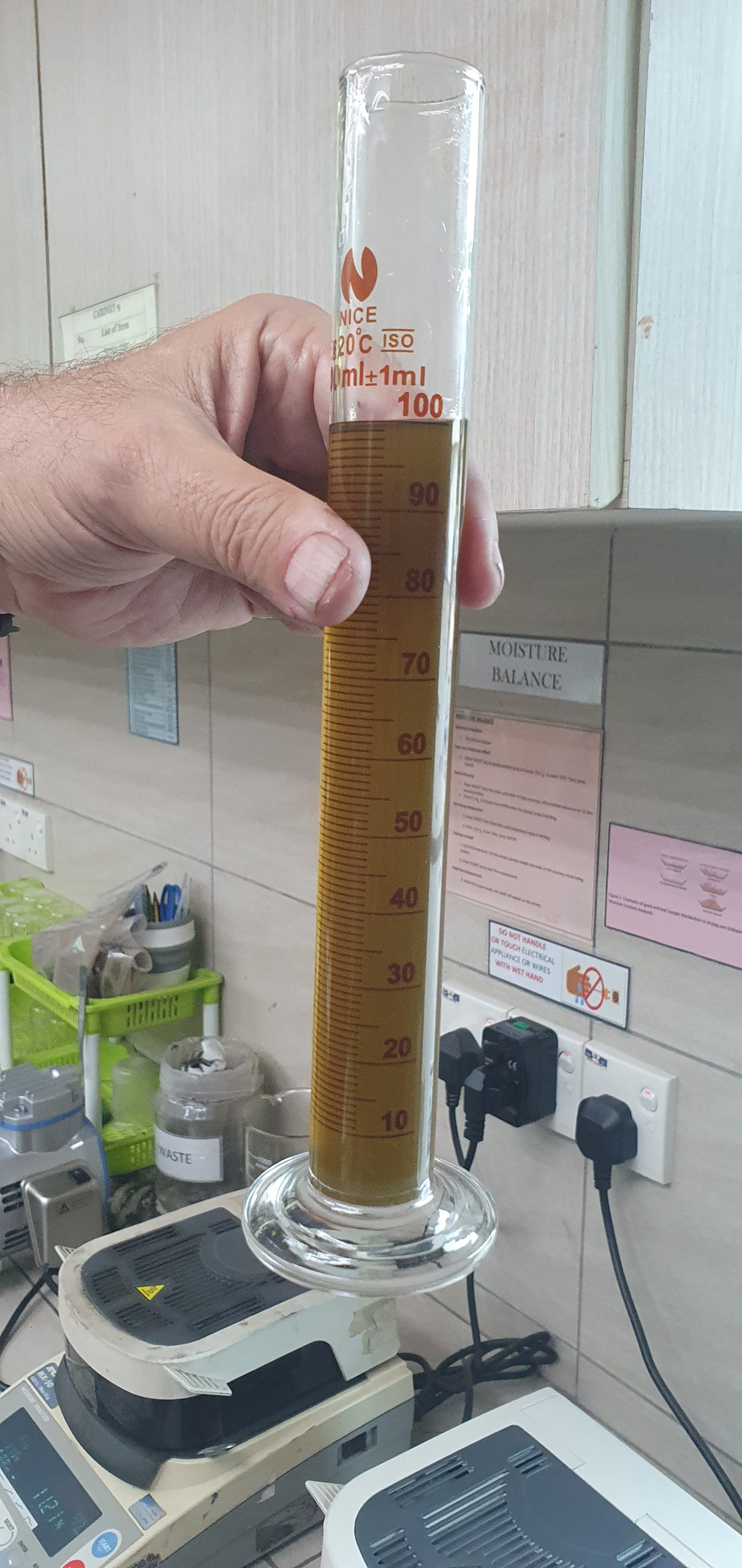 Graduated cylinder holding clear filtrate after solid-liquid separation testing.